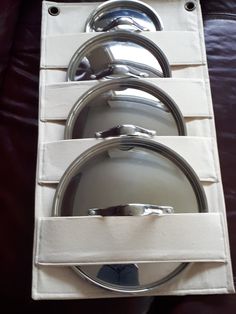 three silver plates in a white box on a leather surface