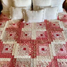 a bed with white pillows and pink quilted bedspread on top of it