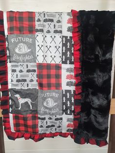 a red and black quilt hanging on a wall