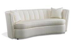 a white couch with two pillows on it's back and one arm facing the camera