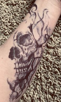 a person with a skull tattoo on their arm