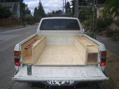 the back end of a white truck with wooden drawers in it's flat bed