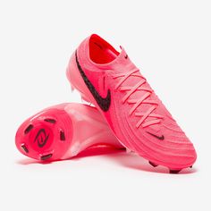 a pair of pink soccer shoes with black and red accents on the upper part of the shoe