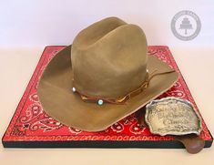 a cowboy hat and wax stamp sitting on top of a red bandanna