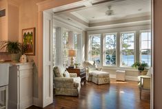 a living room filled with furniture next to a window covered in lots of windows and doors