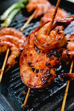 shrimp skewers are being cooked on a grill