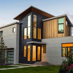 a modern house with lots of windows and grass