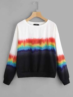 a black and white sweater with rainbow print on the front, hanging from a hanger