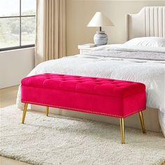 a pink bench sitting on top of a white bed