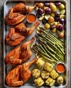 a tray filled with chicken, asparagus and other foods