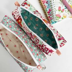 three zippered pouches sitting next to each other on top of a white table