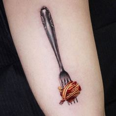 a fork with some food on it that is stuck in the side of a woman's arm