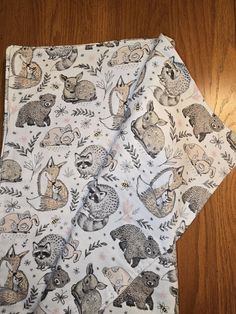 two napkins with animals on them sitting next to each other in front of a wooden floor