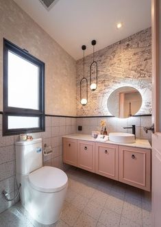 a bathroom with two sinks, a toilet and a large mirror above the sink in it