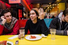 three people sitting at a table in a restaurant