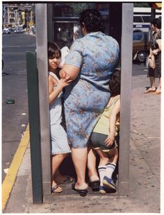 an old photo of people in a public phone booth