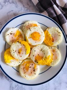 fried eggs on a plate with seasoning sprinkled around them and some salt