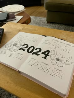 an open calendar book sitting on top of a wooden table