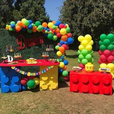 an outdoor birthday party with balloons and legos on the table, along with other decorations