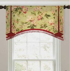 a window with flowers and pom poms on the valance