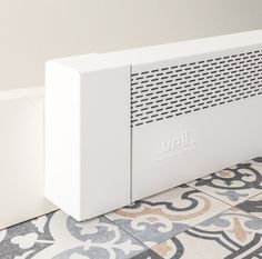 a white wall mounted speaker sitting on top of a tiled floor