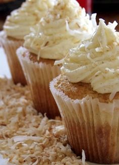 two cupcakes with white frosting and shredded coconut