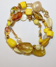 Wear sunshine on your wrist with this sweet and shiny bracelet that features a rare vintage pearl, a Murano see through bead with glass fragments inside, 2 mother of pearl yellow round disks, old glass yellow beads, honey colored crystal large and one small square crystal, white beach glass fragments, semi-precious amber bead and brass accent beads. Elegant Yellow Jewelry For The Beach, Elegant Yellow Beach Jewelry, Yellow Czech Glass Bracelets With Round Beads, Beach Glass Bracelet Jewelry, Yellow Beaded Bangle Jewelry, Yellow Natural Stones Beaded Bracelet, Adjustable Yellow Beaded Bracelets With Natural Stones, Vintage Glass Jewelry For Beach, Gold Bracelets With Large Beads For The Beach