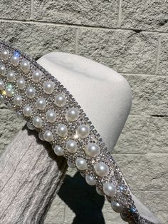 This Perla Rhinestone/Pearl Western Hat is the perfect accessory for the Rodeo & Festival Season or any special event. The white hat features exquisite rhinestones and pearls, adding a touch of glamour to any outfit. Elevate your western look and stand out from the crowd with this stunning hat. Rhinestone & Pearl Detail White Interior Drawstrings For Adjustable Sizing Faux-Suede Thank You For Shopping At Berenis! All Western Hat Sales Are Final! Pearl Hat, Rodeo Time, Western Hat, Western Look, Western Hats, Cowgirl Hats, White Hat, Hats For Sale, Hat Band