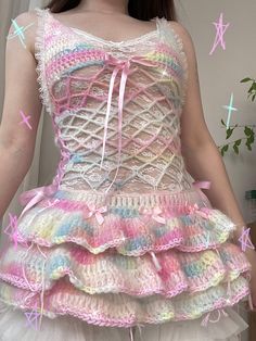 a woman wearing a dress made out of crochet and yarn with pink bows