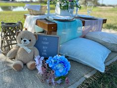 a teddy bear sitting on top of a table next to flowers and a sign that says it's today