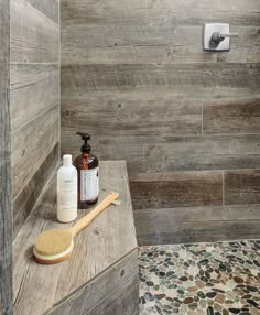 a wooden shower stall with soap, scrubber and lotion on the counter next to it