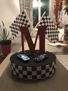 the letter m is placed on top of a table with two cell phones in front of it