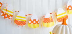 an orange and white bunting banner with polka dots on it, next to a pumpkin