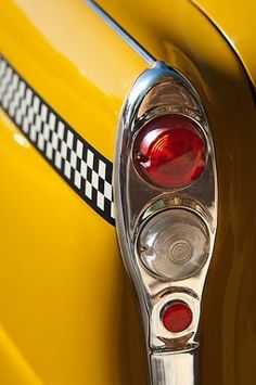 the tail light of a yellow car with black and white checkerboard on it