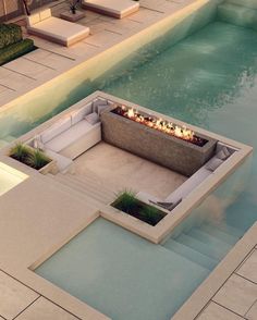 an outdoor fire pit in the middle of a swimming pool