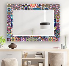 a colorful mirror hanging on the wall above a table