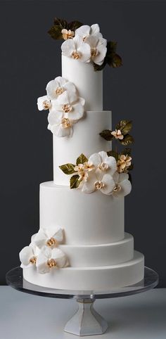 a three tiered white cake with flowers on top