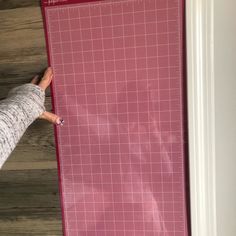 a person cutting up a piece of pink paper