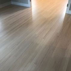 an empty room with hard wood flooring and white trim on the door way to another room