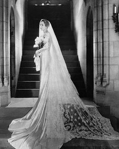 an old photo of a woman in a wedding dress on the steps of a building