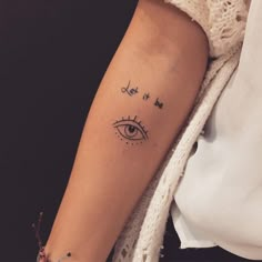 a woman's arm with an eye tattoo on it