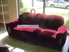 a red couch sitting in front of a window