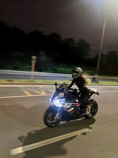 a person riding on the back of a motorcycle at night