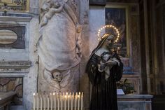 the statue is holding a baby in her arms next to an altar with candles on it