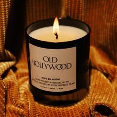 an old hollywood candle is sitting on a bed