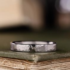 a close up of a wedding ring on top of an open book with a blurry background