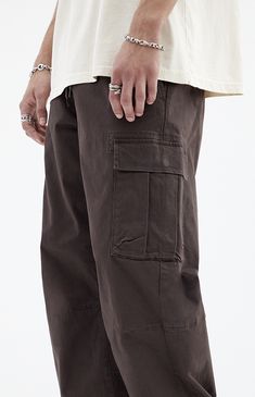 Stay effortlessly stylish with PacSun's Brody Brown Cotton Cargo Pants. With their relaxed fit, zip fly closure, and functional cargo pockets, these pants combine comfort and utility in a trendy brown finish, perfect for any casual outing.   	Model is wearing a size medium 	Model Measurements: 6'1” Height, 31” Waist, 32” Inseam   Learn more about PacSun eco items Black Mens Streetwear, Brown Baggy Jeans, Woodstock Outfit, Brown Cargo Pants Outfit, Brown Cargos, Mens College Fashion, Thanksgiving Play, Cargo Pants Outfit Men, Mens Cargo Pants