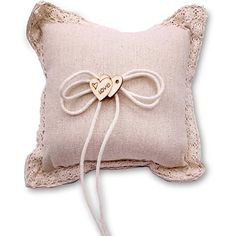 a small pillow with a wooden heart on the front and a string attached to it