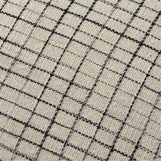 close up view of the fabric textured with black and white squares on beige background