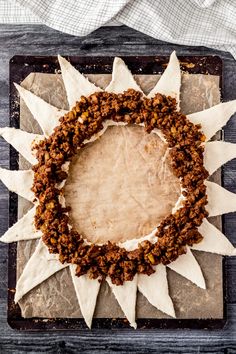 a wreath made out of doughnuts on top of a wooden table with napkins